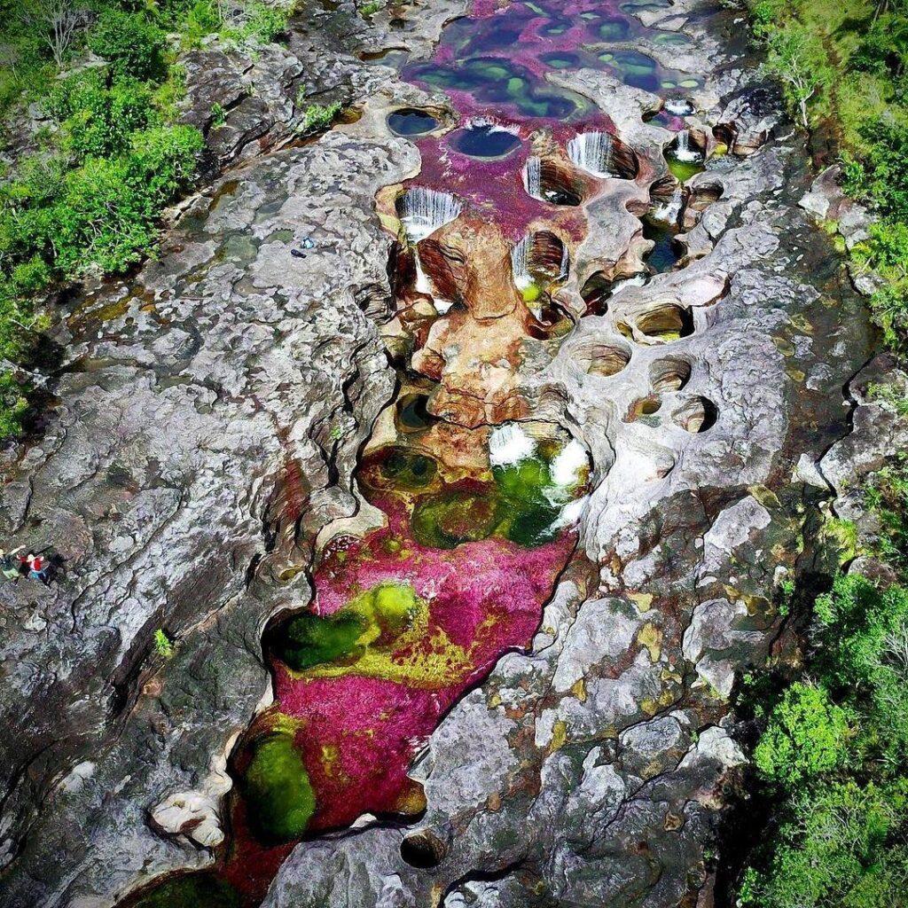 El Rio de colores en su esplendor, enmarcado en rocas milenarias.